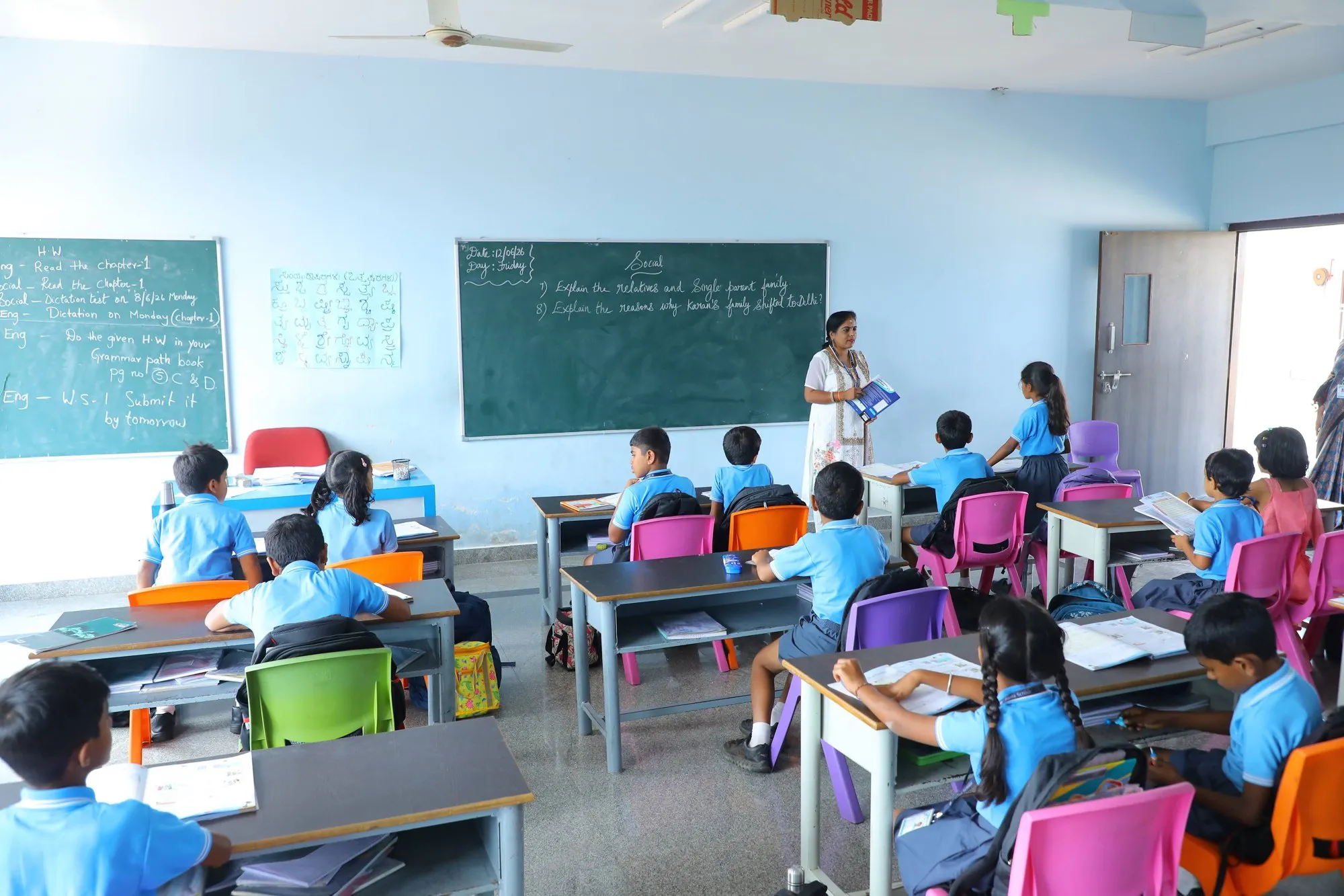 A teacher leading a middle-school lesson at the blackboard