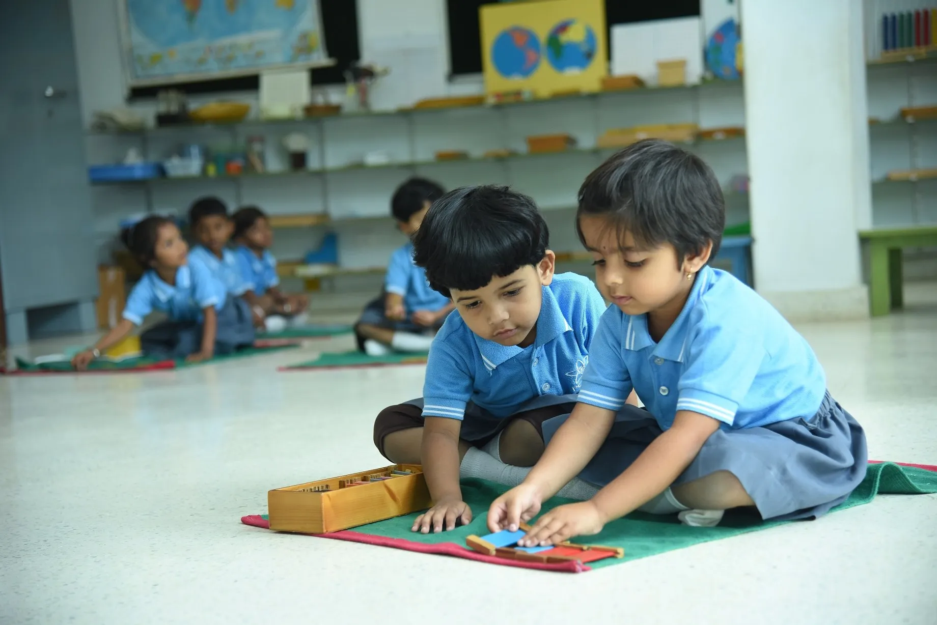 Montessori children at work on their floor mats