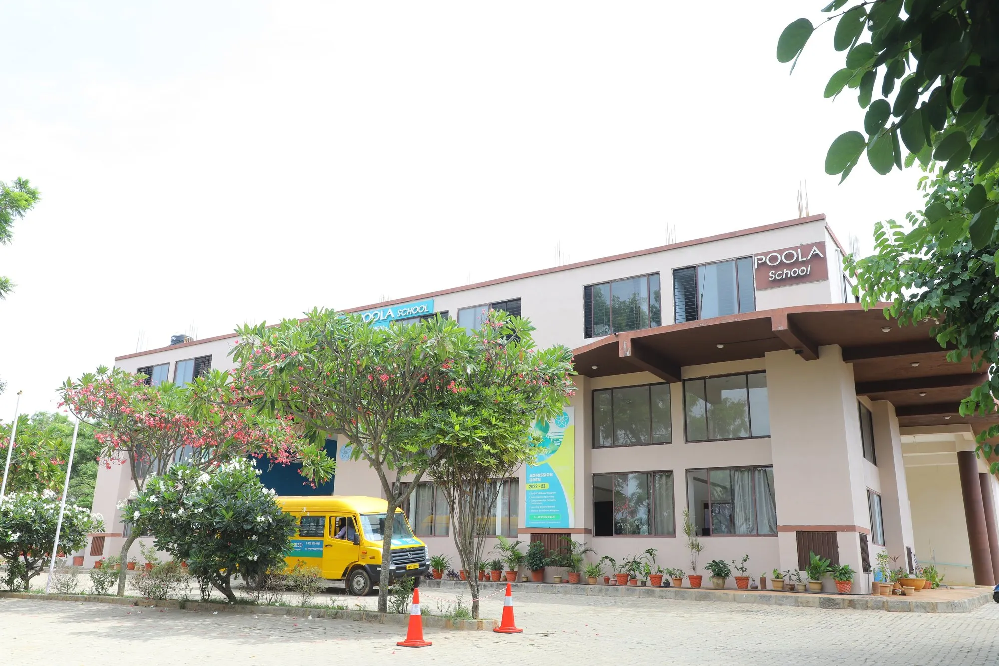The Poola School building today, seen from the street behind flowering trees