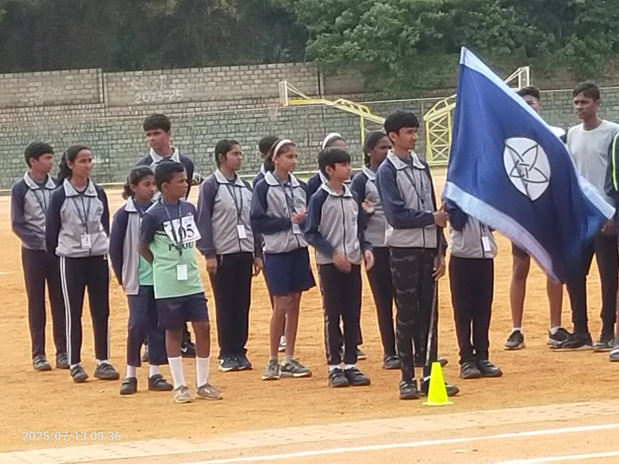 Students lined up with the school flag on sports day