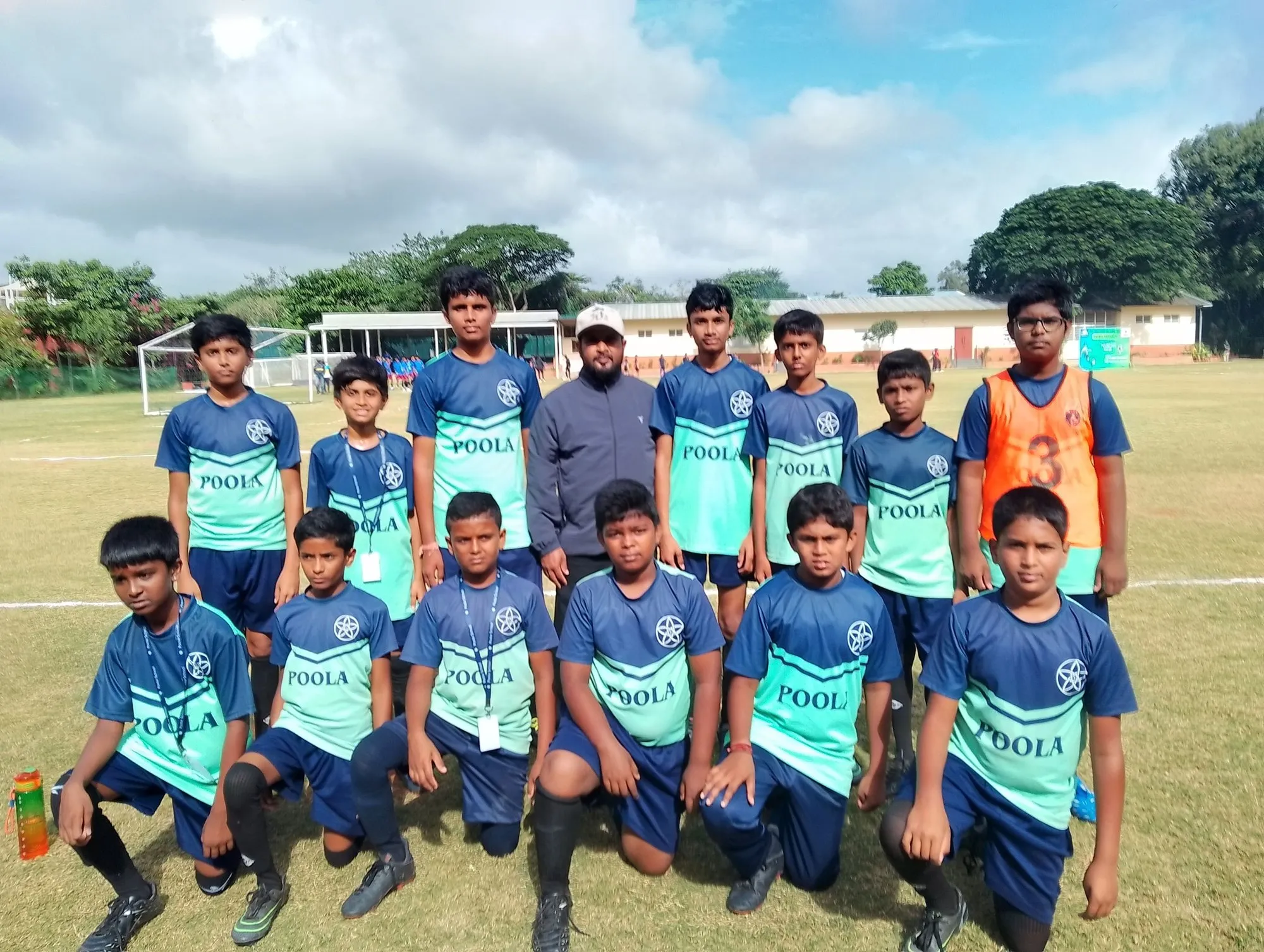The Poola School soccer squad with their coaches on the field